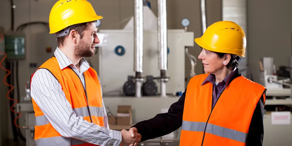 Female and male worker shake hands